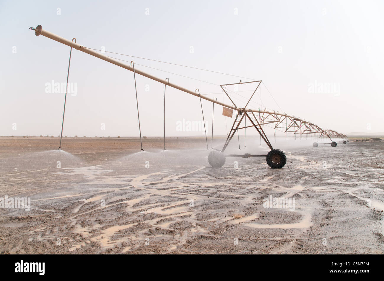 A solar-powered center pivot irrigation system spraying water in the Eastern Desert of the Hashemite Kingdom of Jordan. Stock Photo