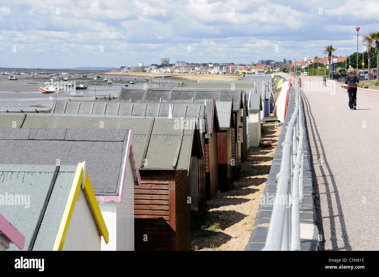 Seafront Beach Huts on sandy beach at Shoeburyness promenade & views towards Southend on Sea seaside resort & pier on Thames Estuary Essex England UK Stock Photo