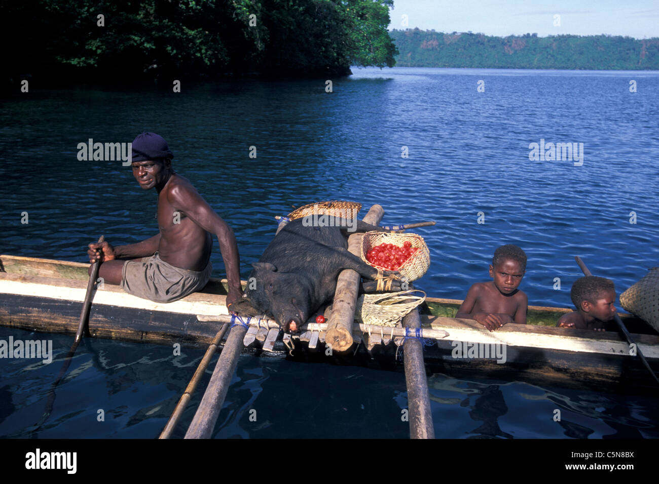 Inhabitans Family with Pork on Trigger Boat, Vitu Islands, Bismarck Archipelago, Papua New Guinea Stock Photo