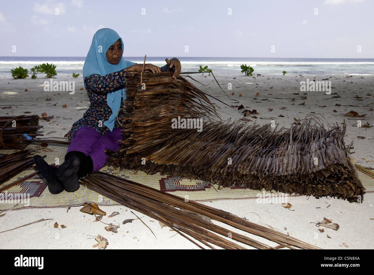 Woman at work, Indian Ocean, Maldives Stock Photo