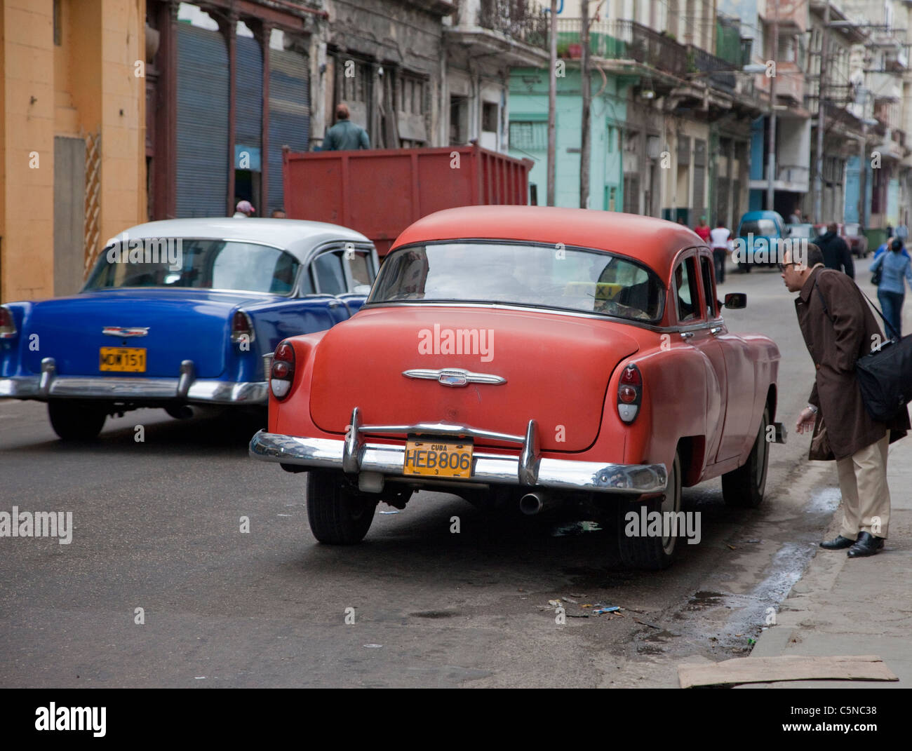 Cuba, Havana. Early Morning Central Havana Street Scene. Looking for a Taxi. 1950s Chevrolets. Stock Photo