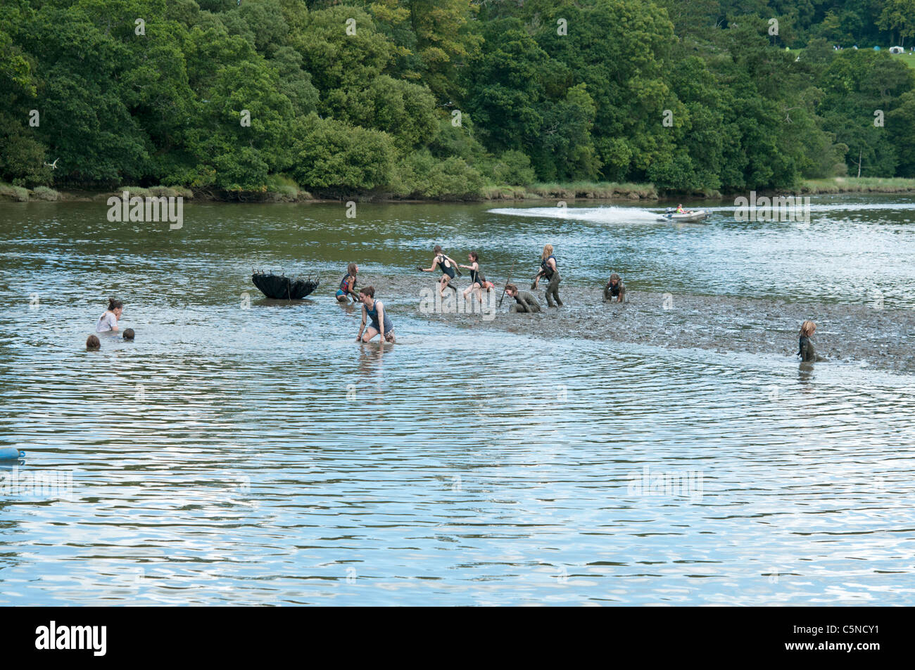 Swimmers having fun in the estuary mud at the Port Eliot Literary Festival St Germans Cornwall UK Stock Photo