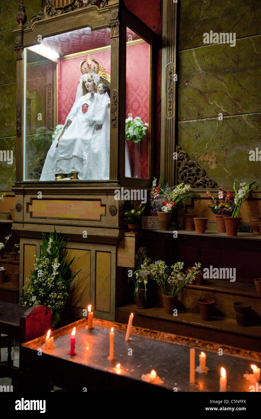 Cuba, Havana. Church of La Merced, Mary and Jesus, with Votive Candles. Stock Photo