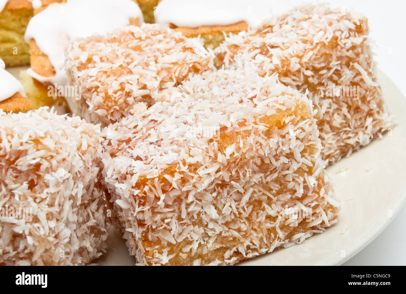Traditional Madeleines coated in jam and covered with coconut sprinkles. Stock Photo