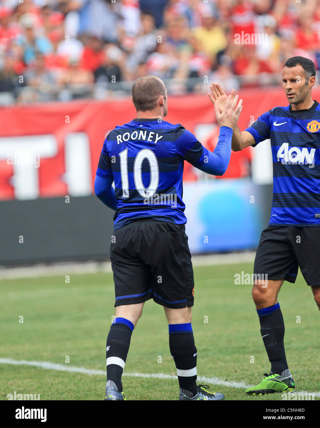 Manchester United mid-fielder, Ryan Giggs (R), congratulates striker, Wayne Rooney (10) on his goal vs. the Chicago Fire. Stock Photo