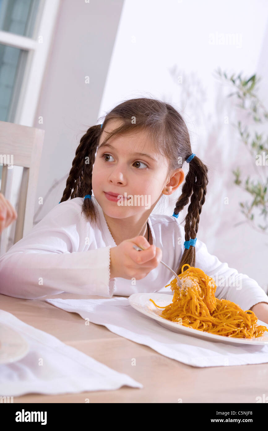 Girl eating spaghetti with tomato sauce Stock Photo Alamy