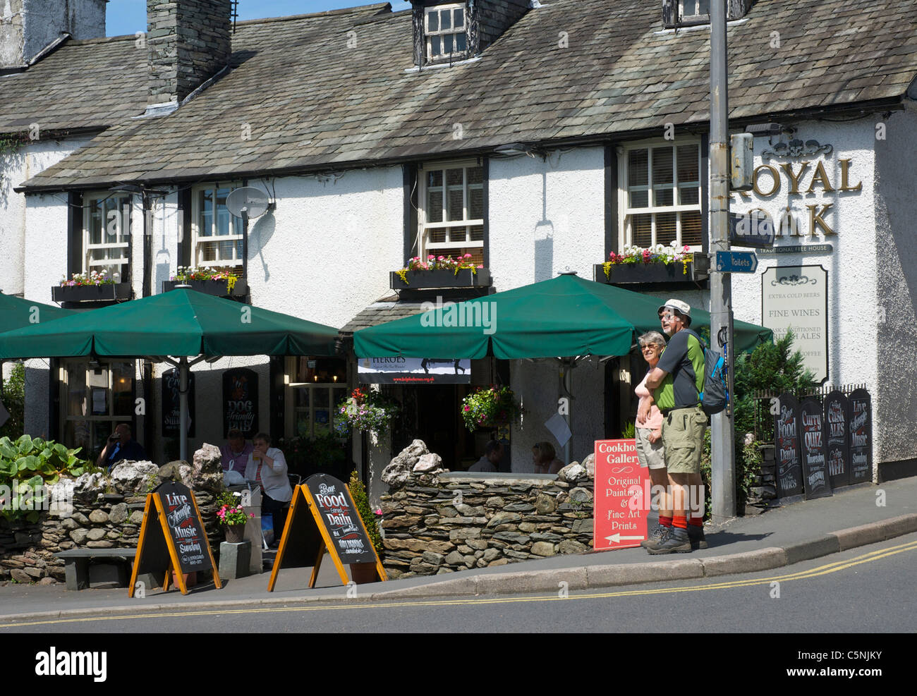 Man and woman walking past the Royal Oak pub in Ambleside, Lake