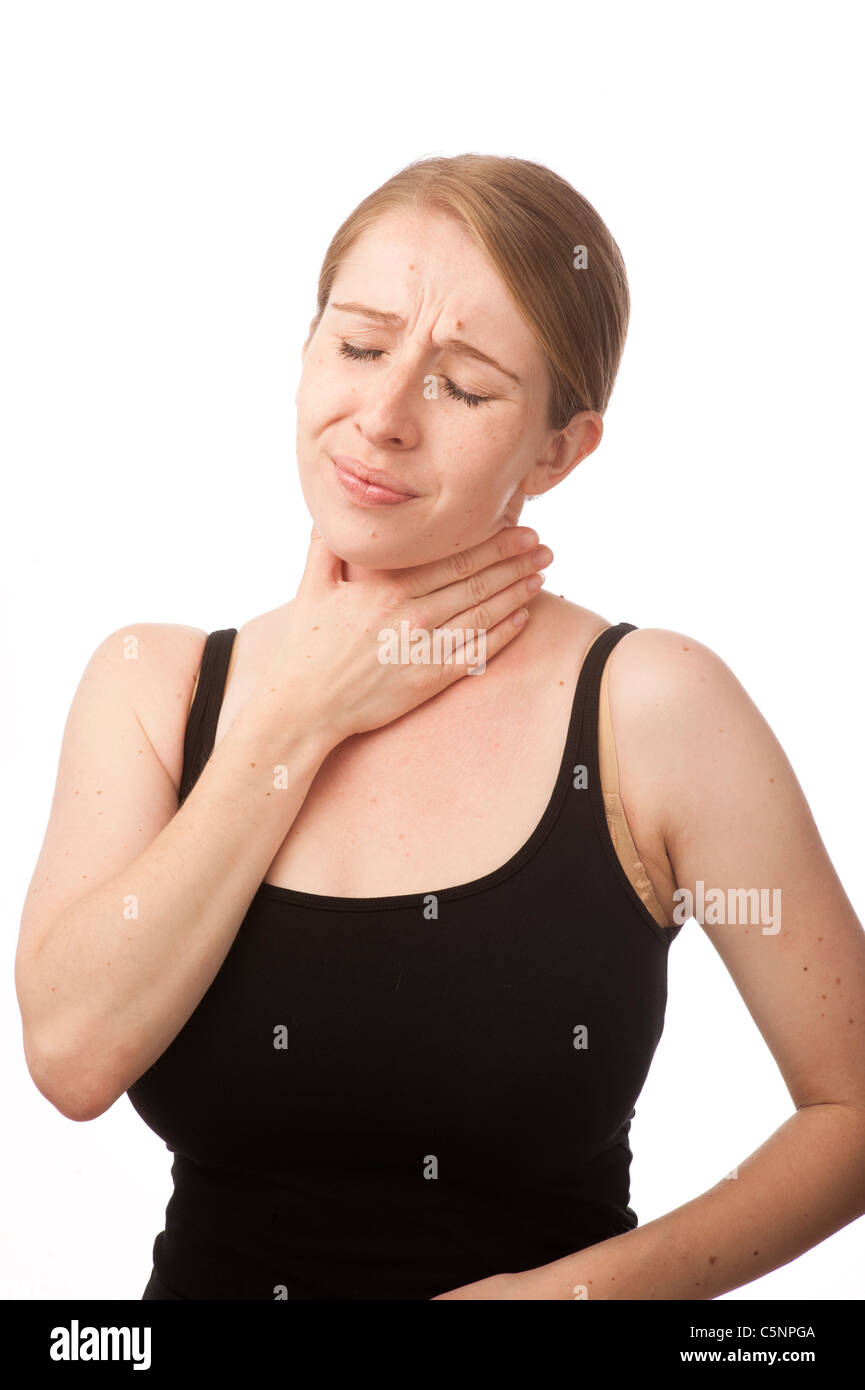 a young caucasian woman suffering with a sore neck pain in her throat, rubbing her neck for relief Stock Photo