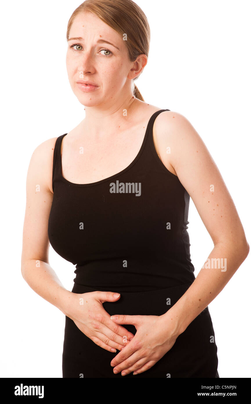 a young caucasian woman pressing her midriff suffering from belly ache or stomach cramps period pains Stock Photo