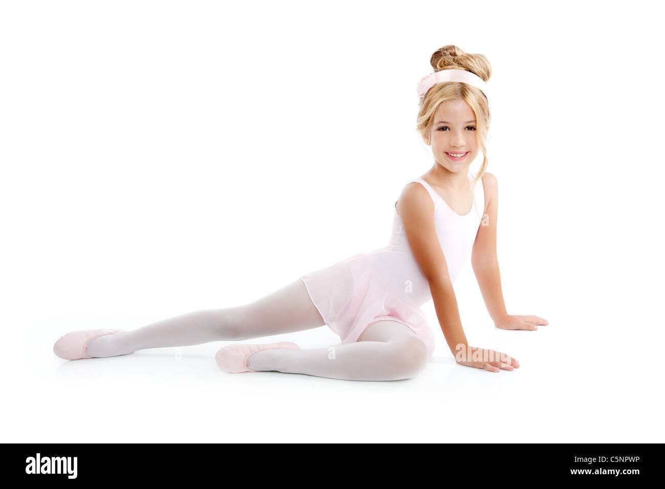 Ballerina little ballet children dancer stretching sitting on white floor Stock Photo
