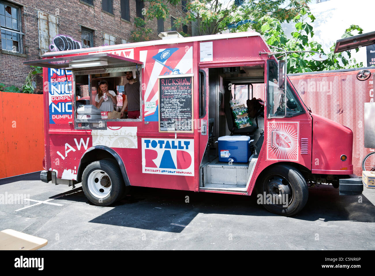 bright pink Thai dumpling food truck parked in lot next to High Line elevated park entrance Chelsea district New York City Stock Photo