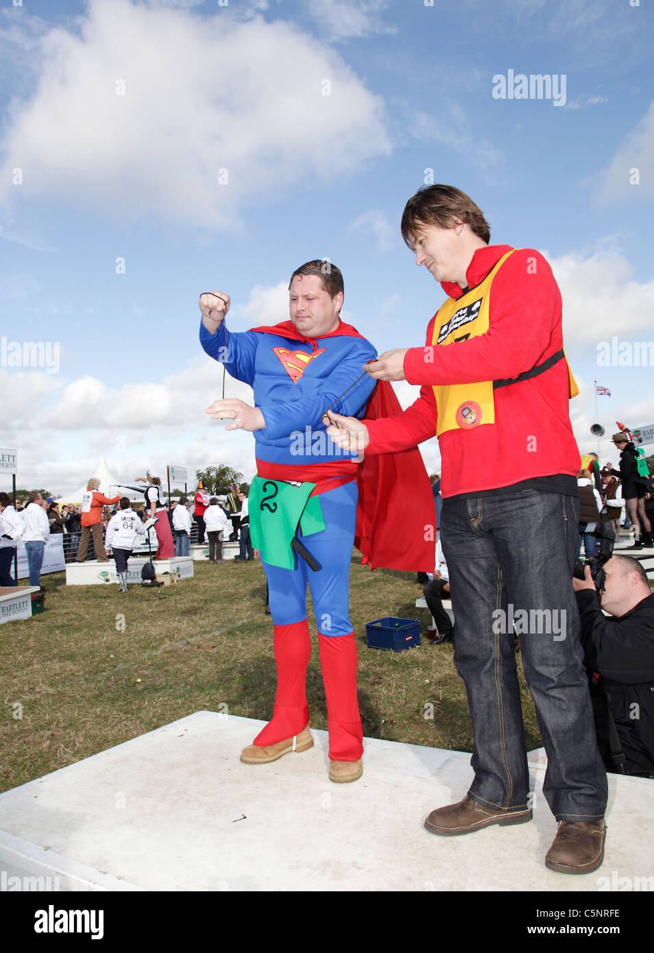 Two men, one dressed as Superman, playing conkers at the World Conker Championships held at Oundle,Northamptonshire Stock Photo