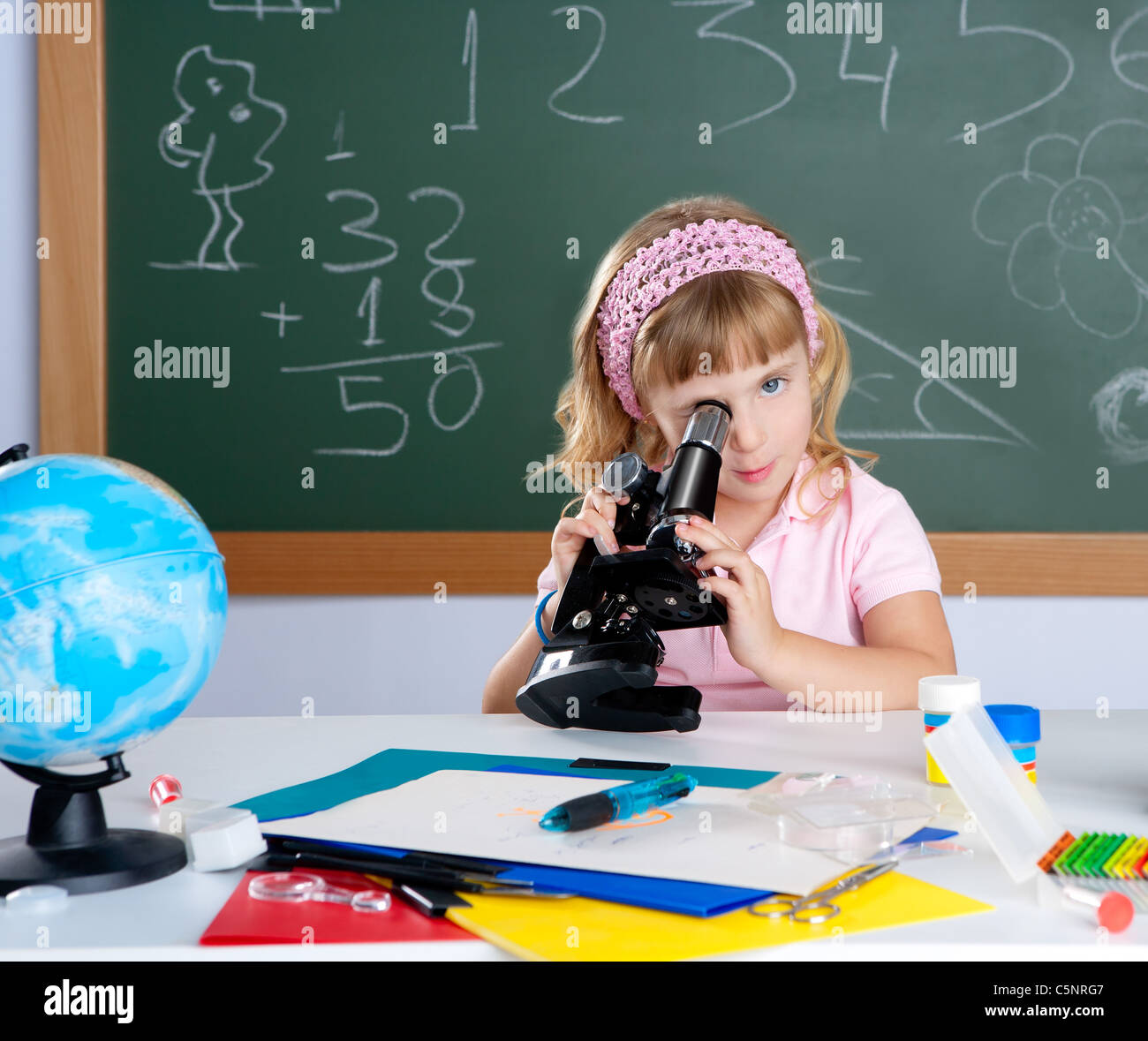 children little girl at school classroom with microscope in science