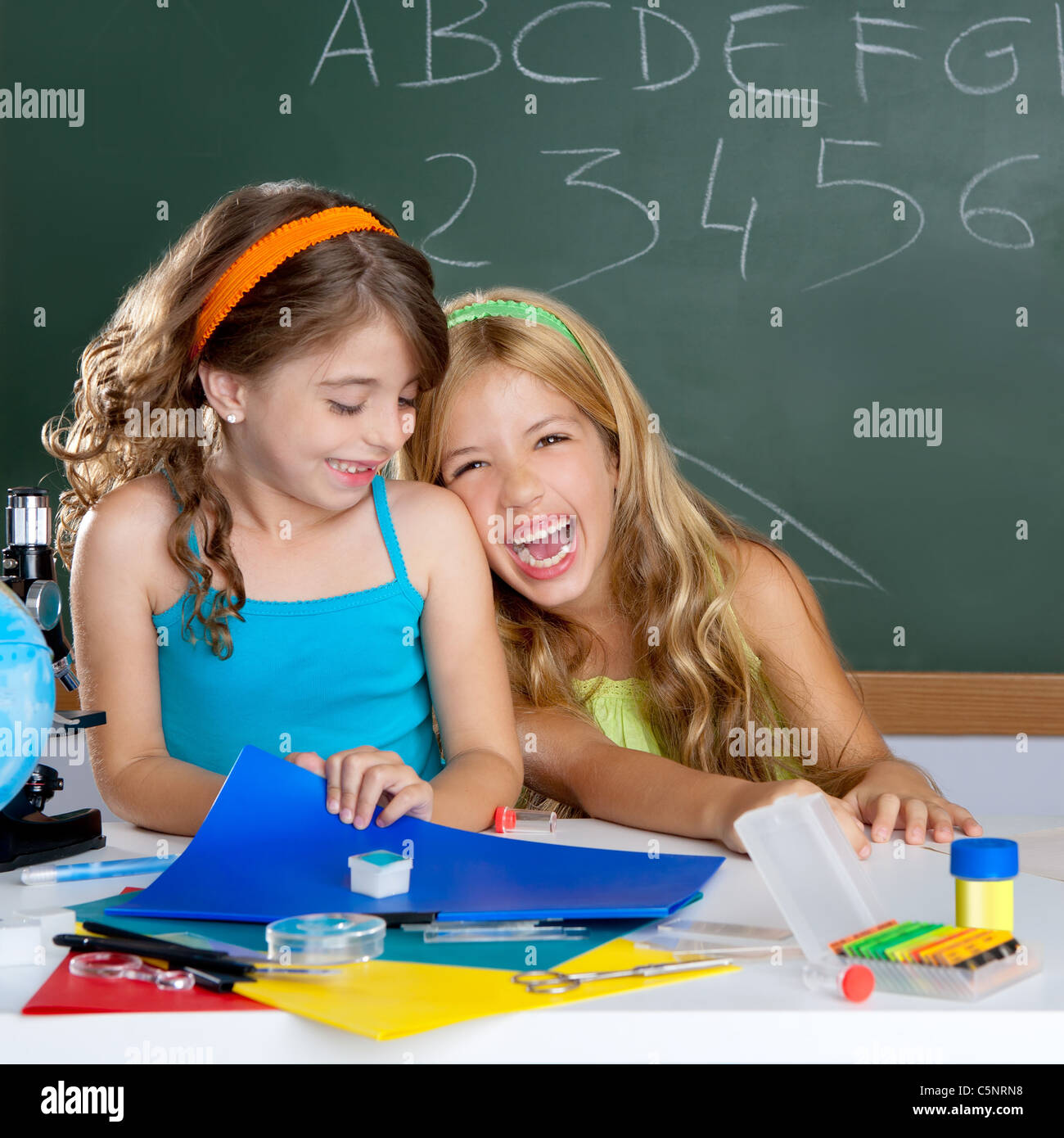 happy laughing kids student girls at school classroom in ...