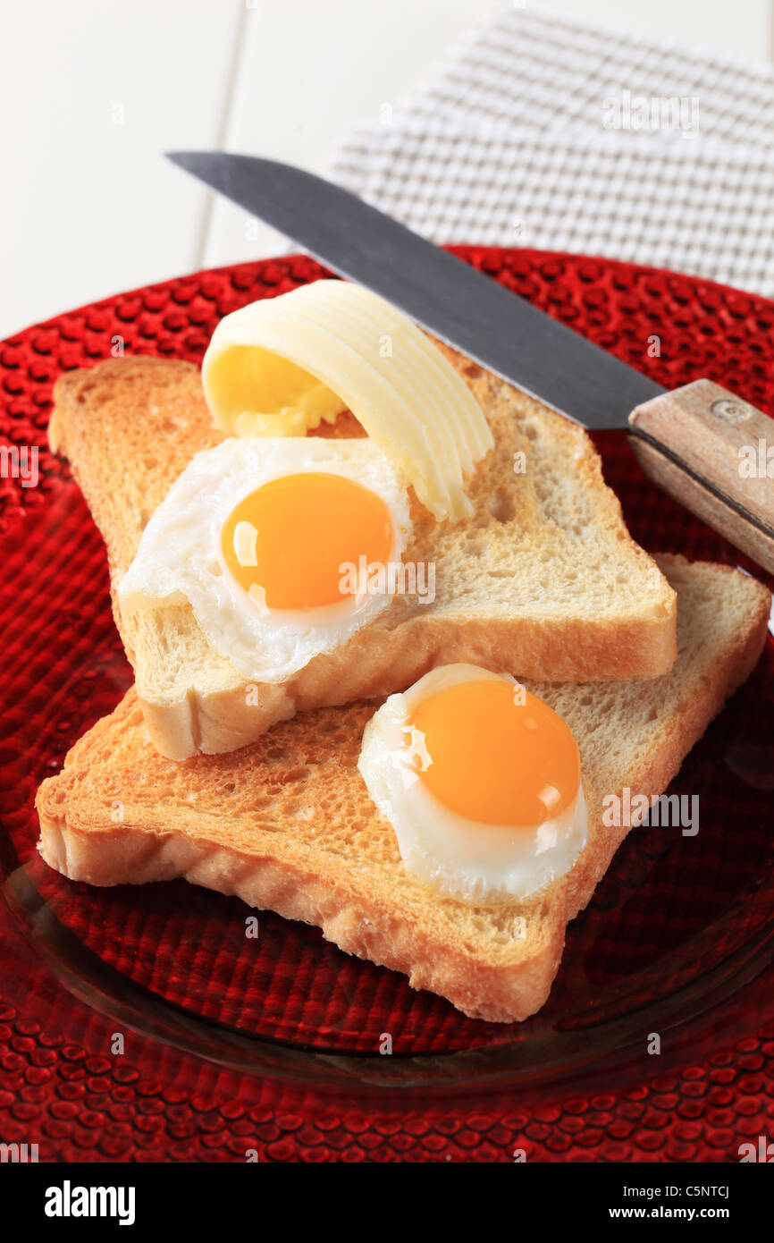Fried eggs on slices of toasted bread Stock Photo