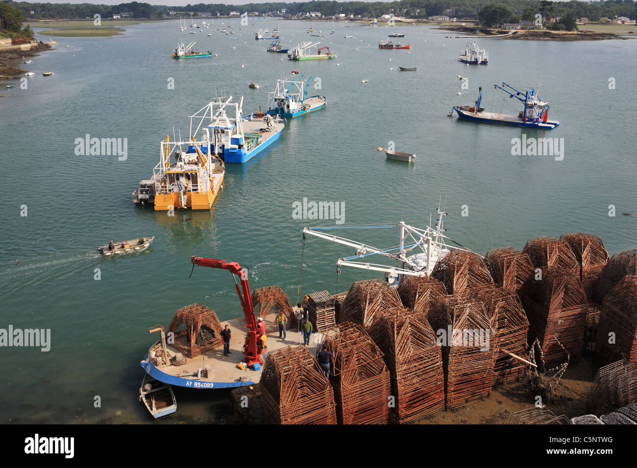 Boats being prepared for oyster farming or fishing. Seen from the Pont de Kerisper,  Morbihan, Brittany Stock Photo