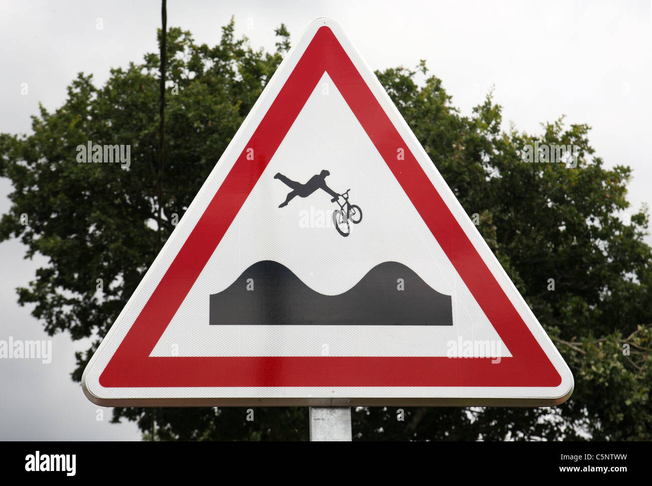 A road sign warning cyclists of an uneven surface ahead that could lead to them being thrown from their bikes. Brittany, France. Stock Photo