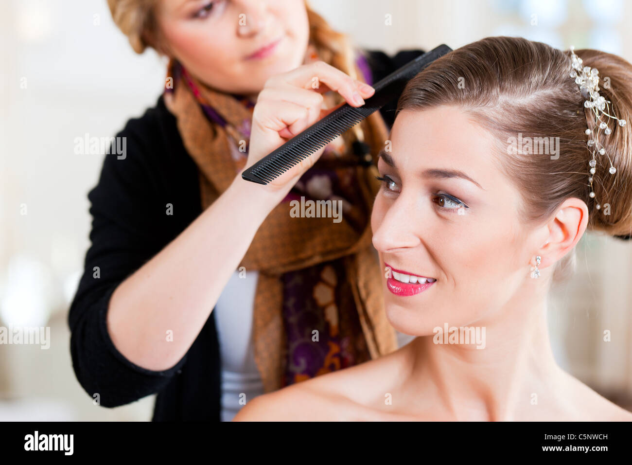 Stylist pinning up a bride's hairstyle before the wedding Stock Photo