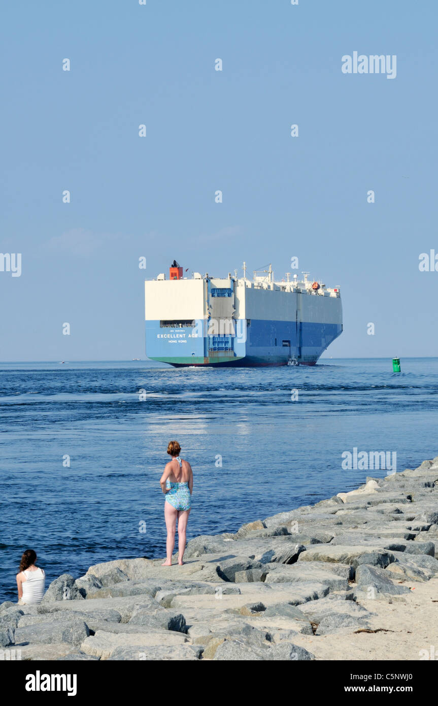 Auto carrier transport ship with person on jetty in foreground, USA. Stock Photo
