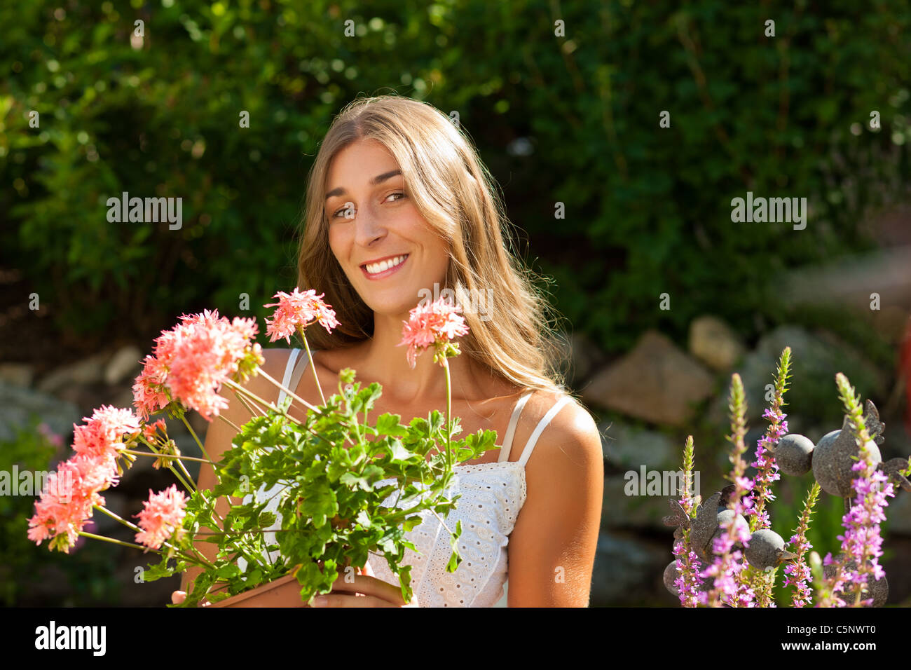 Gardening in summer - happy woman with flowers in her garden Stock ...