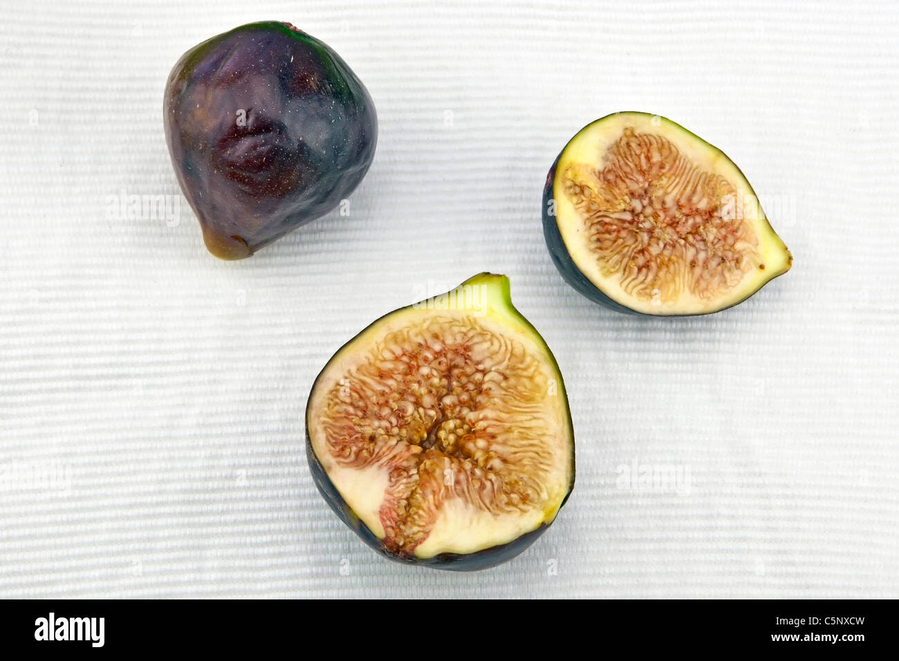 a whole and two halves of fresh figs Stock Photo