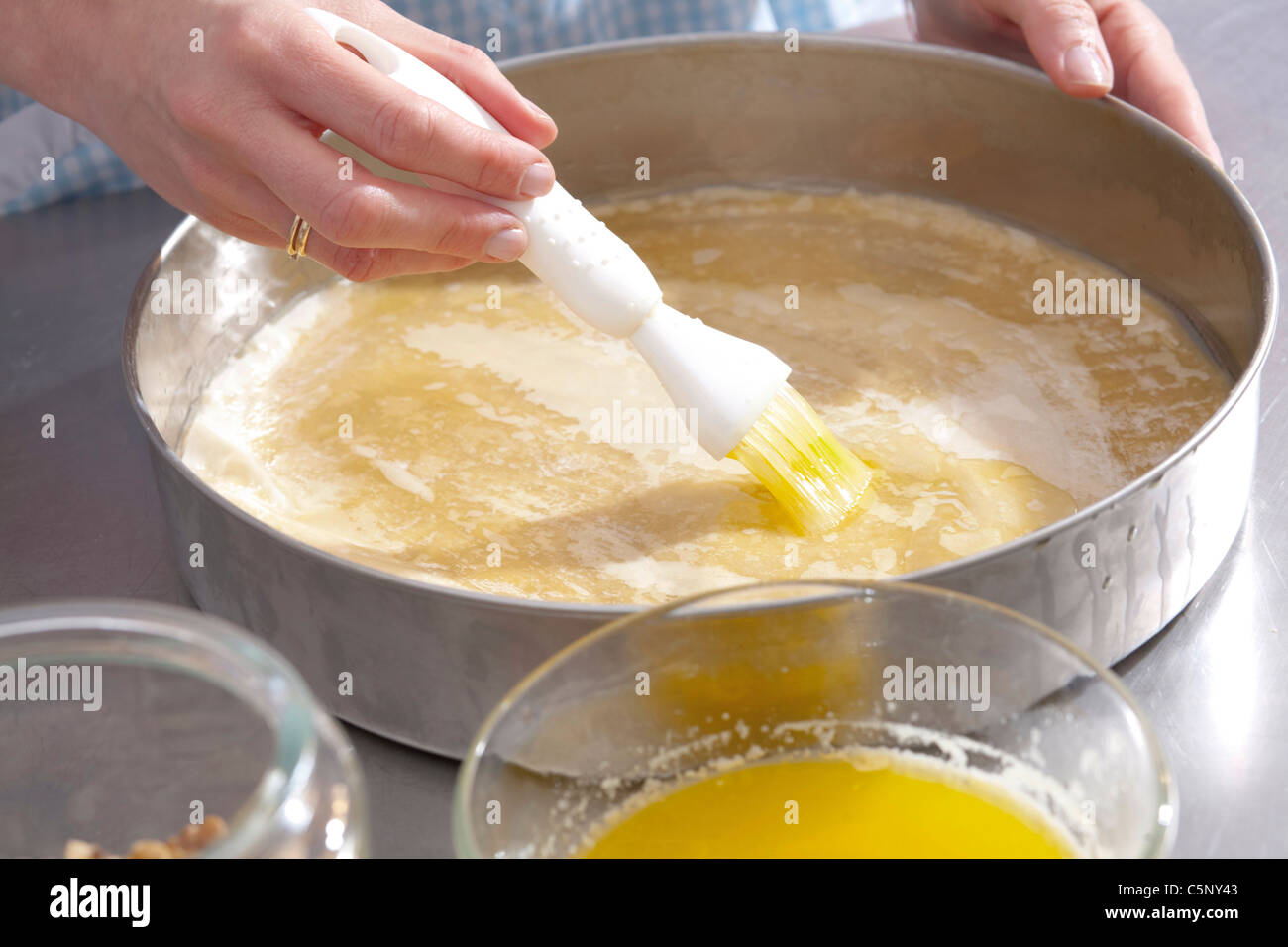 Baklava: spreading filo pastry with hot butter Stock Photo