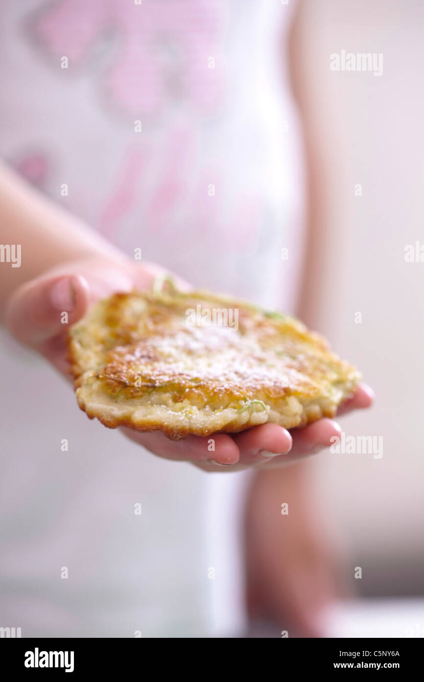 Elderberry pancakes: Child holding a pancake made with elderberries flowers Stock Photo