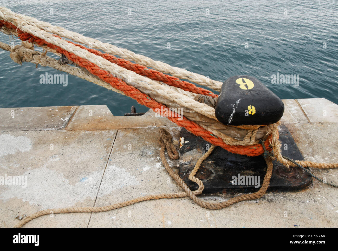 Bollard and mooring ropes at docks Stock Photo