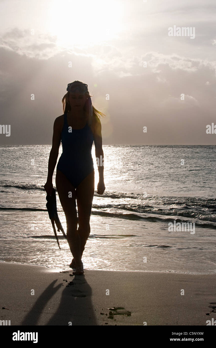 Silhouette of woman at water's edge, Mustique, Grenadine Islands Stock Photo