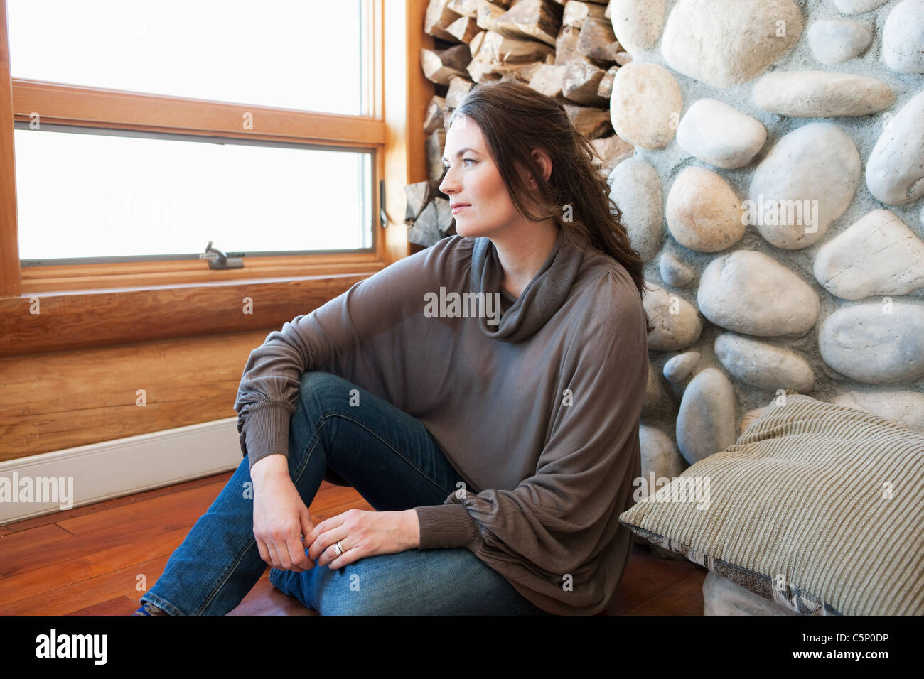 Woman sitting in log cabin, portrait Stock Photo