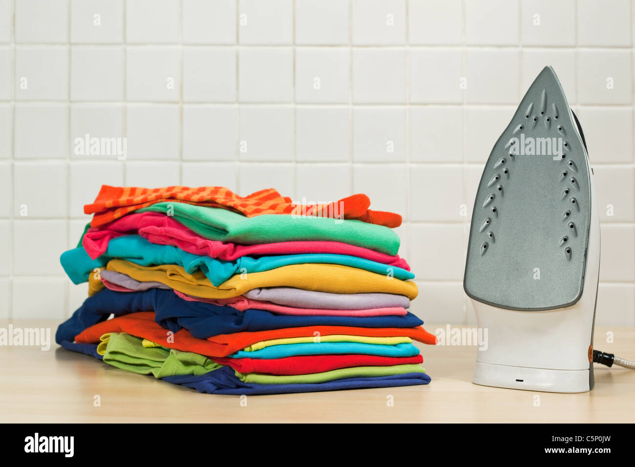 Piles of clean laundry and iron Stock Photo Alamy