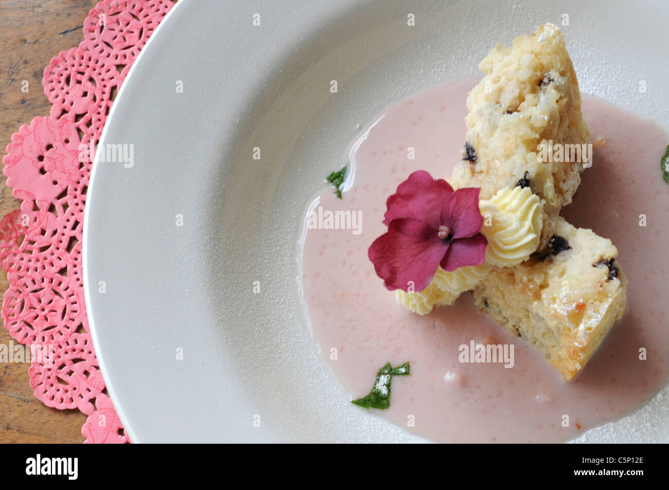 Rice pudding with sultanas on rose sauce Stock Photo
