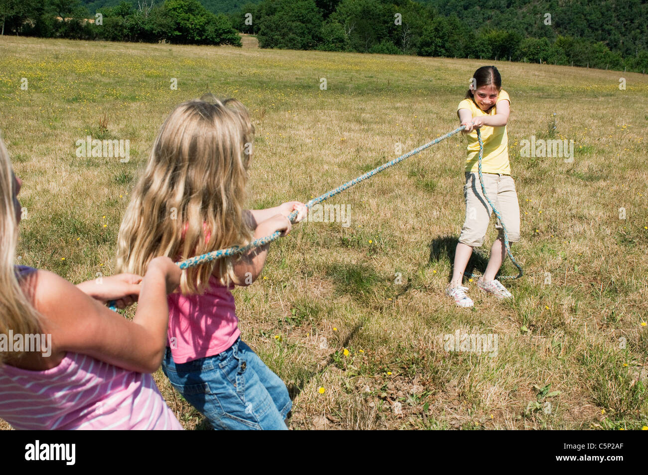 side view of cute little multiethnic children pulling rope in park Stock  Photo - Alamy