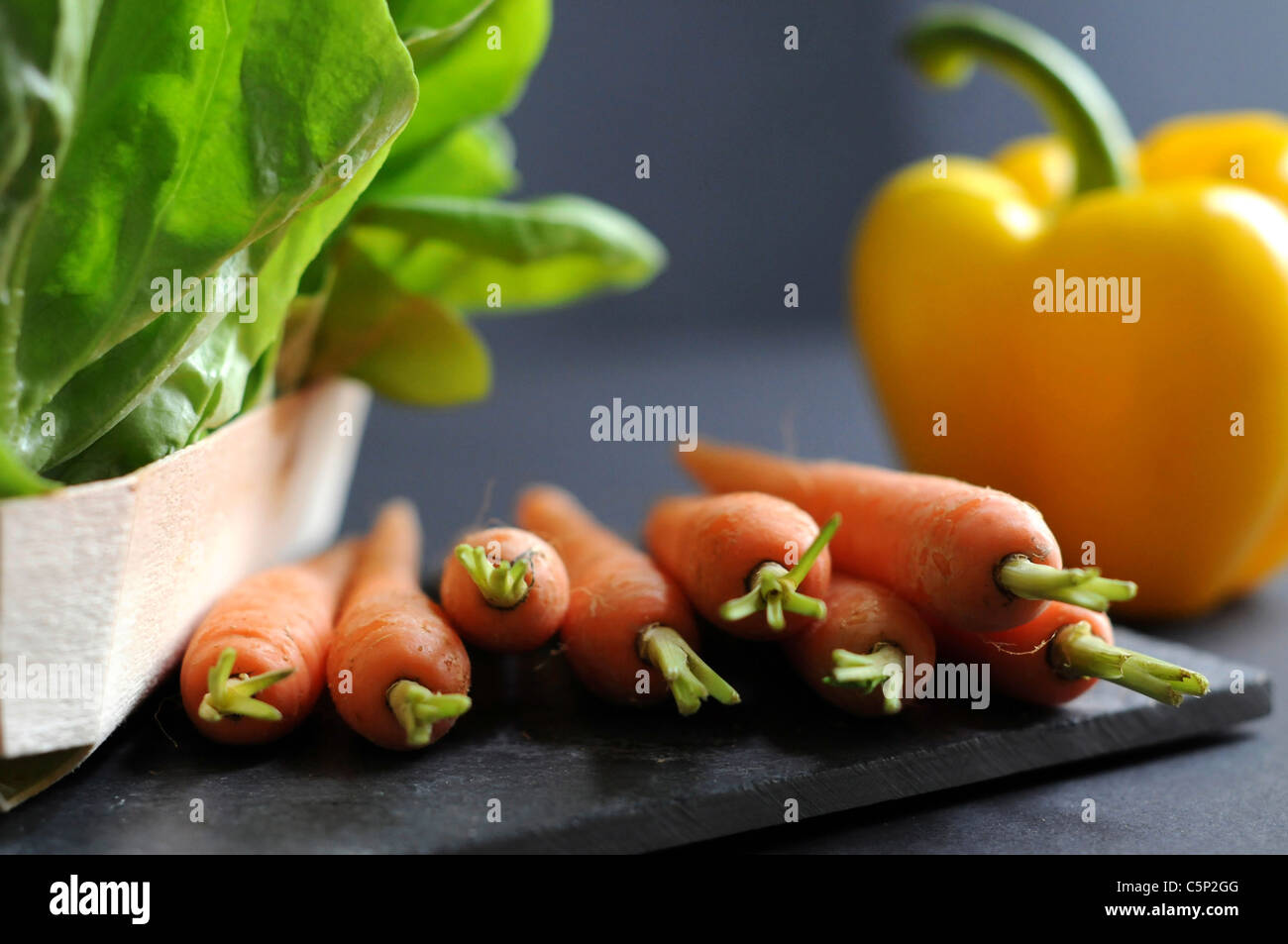 Carrots and one yellow sweet pepper bell with lettuce Stock Photo