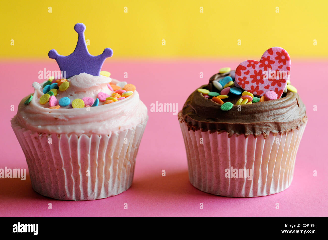 Vanilla and chocolate cupcake with  frosting and sugar sprinkles, heart and crown Stock Photo
