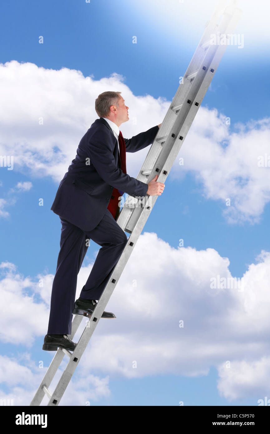 Concept photo of a businessman climbing a ladder into the sky looking up into the light. Stock Photo