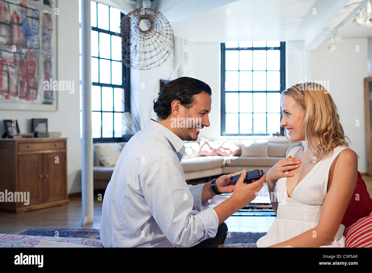 Man surprising wife with gift Stock Photo - Alamy