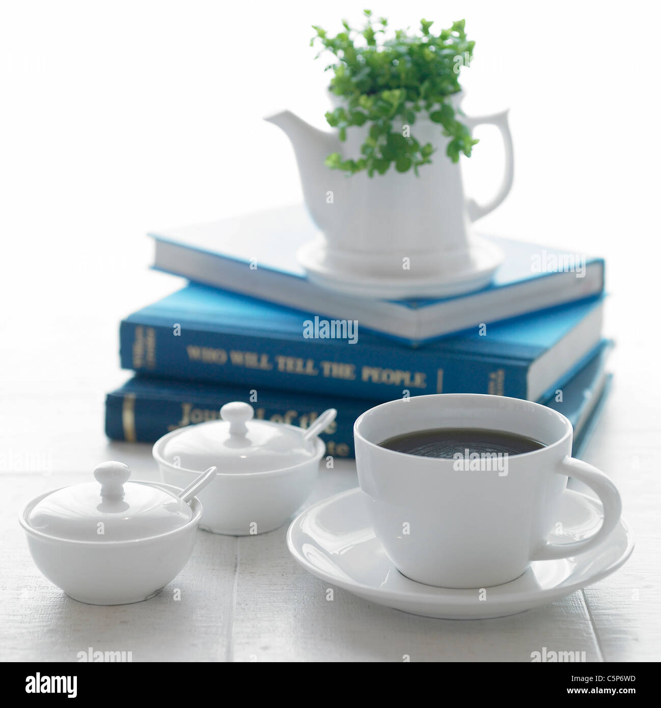 A coffee cup and other objects on a table Stock Photo