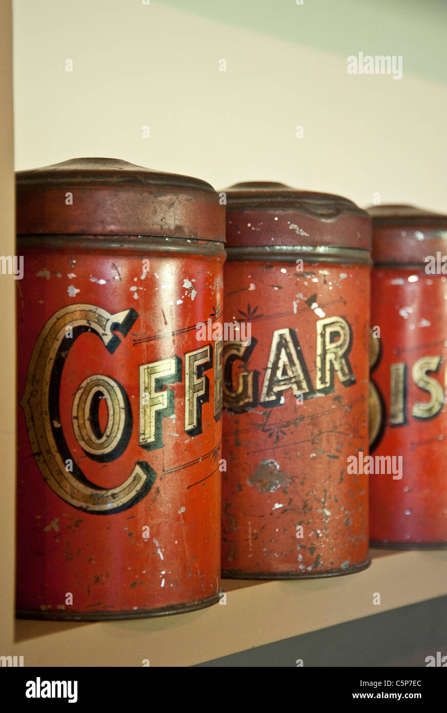 Old food storage tins on shelf Stock Photo