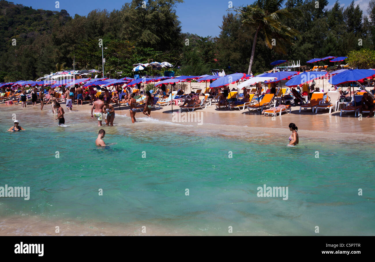 View over beach and bay with tourists on beach and in clear blue water Nai Harn near Cape Promthep Stock Photo