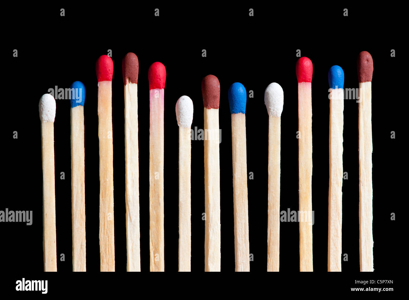 match with white, red, blue and brown head in line, black background Stock Photo