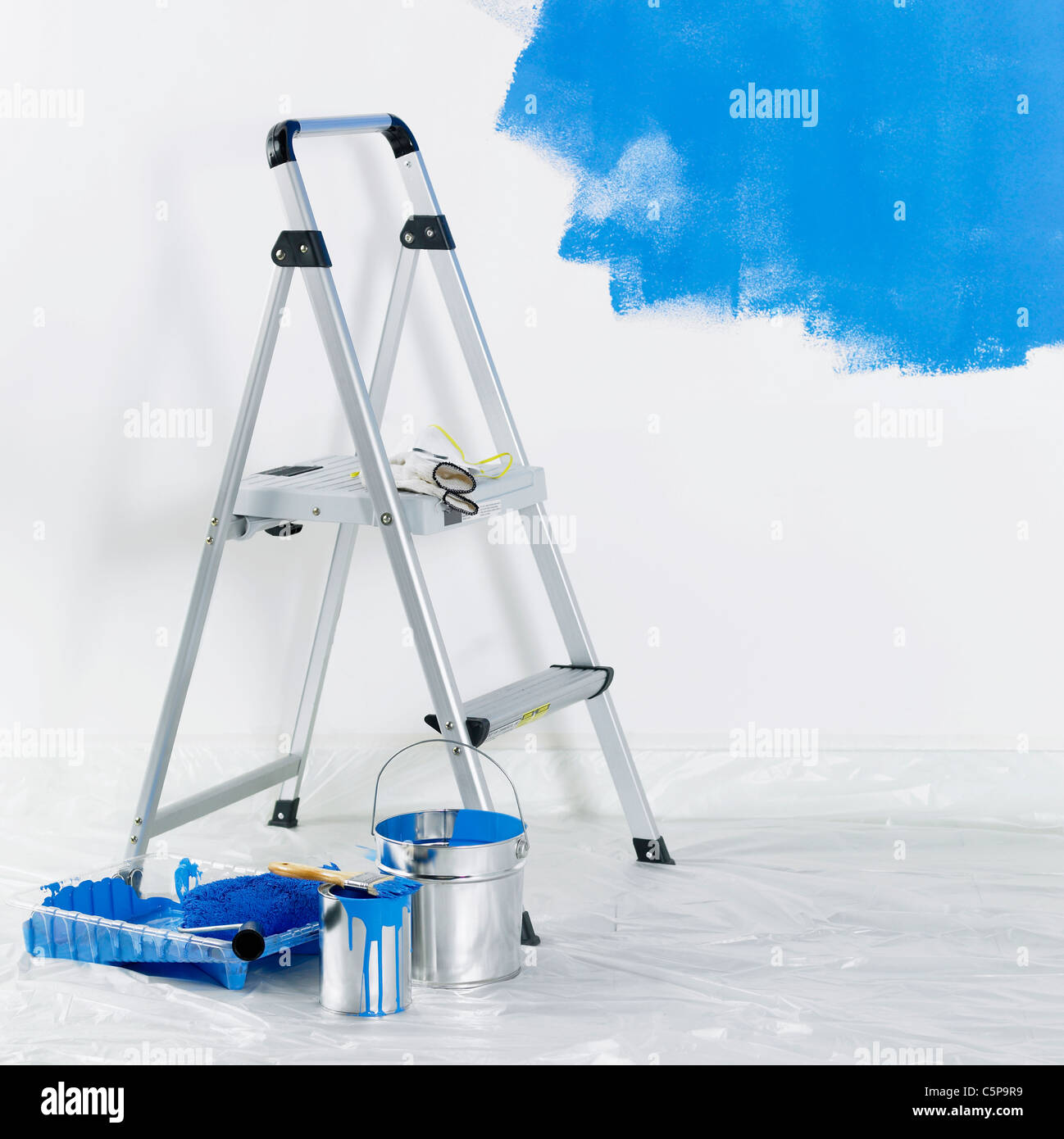 A ladder, paint bucket with painted wall Stock Photo - Alamy