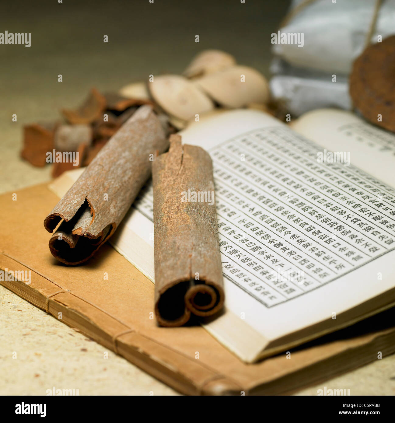 Dried medicinal herbs and ancient book Stock Photo