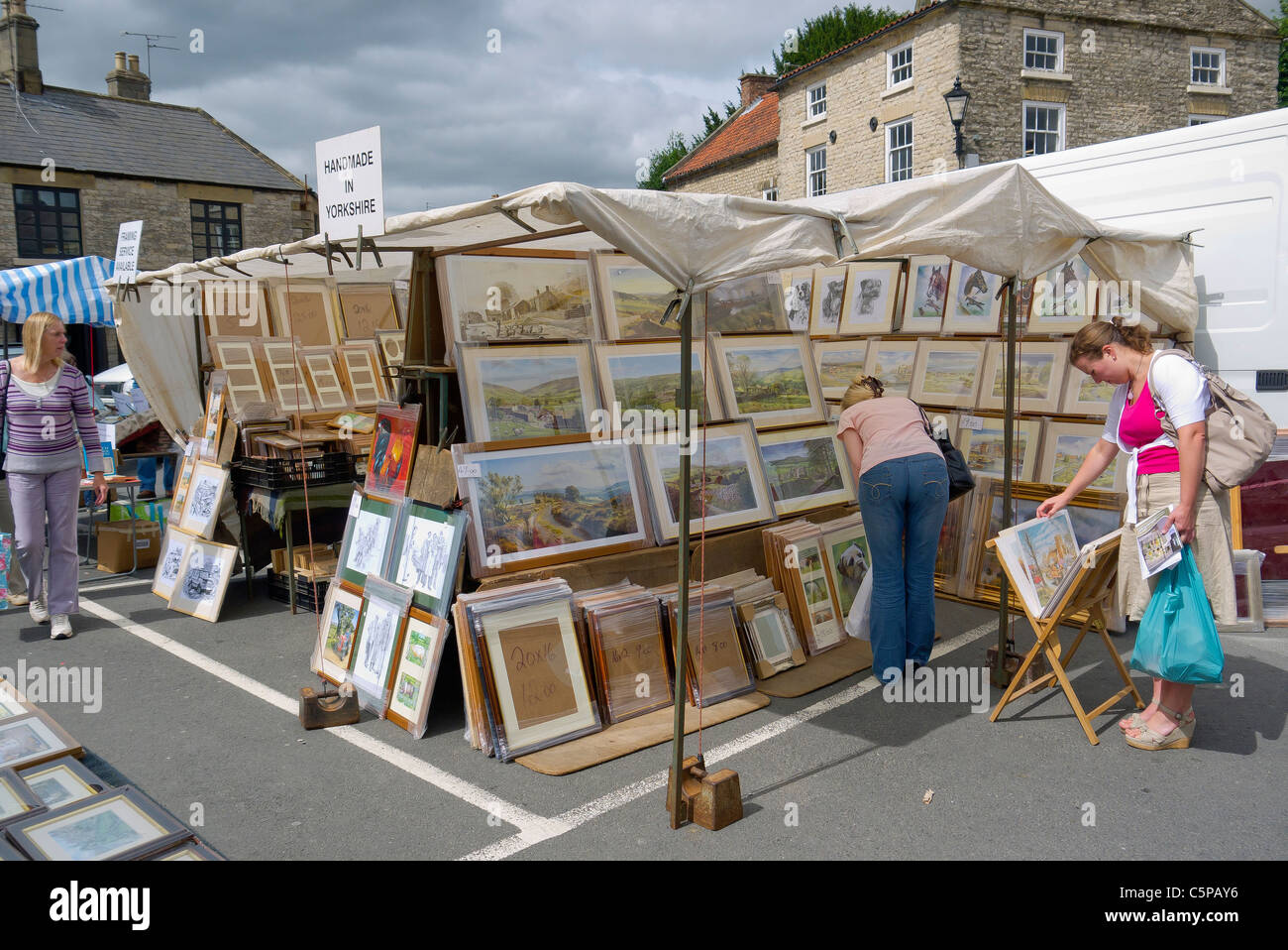 Shoppers at a picture stall at the weekly Friday Market in the square at Helmsley North Yorkshire Stock Photo