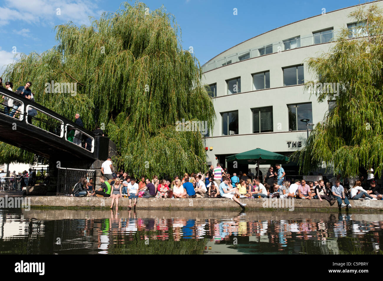 Young people people relaxing outside the Ice Wharf pub on the Regent's Canal in Camden Town, London, UK Stock Photo