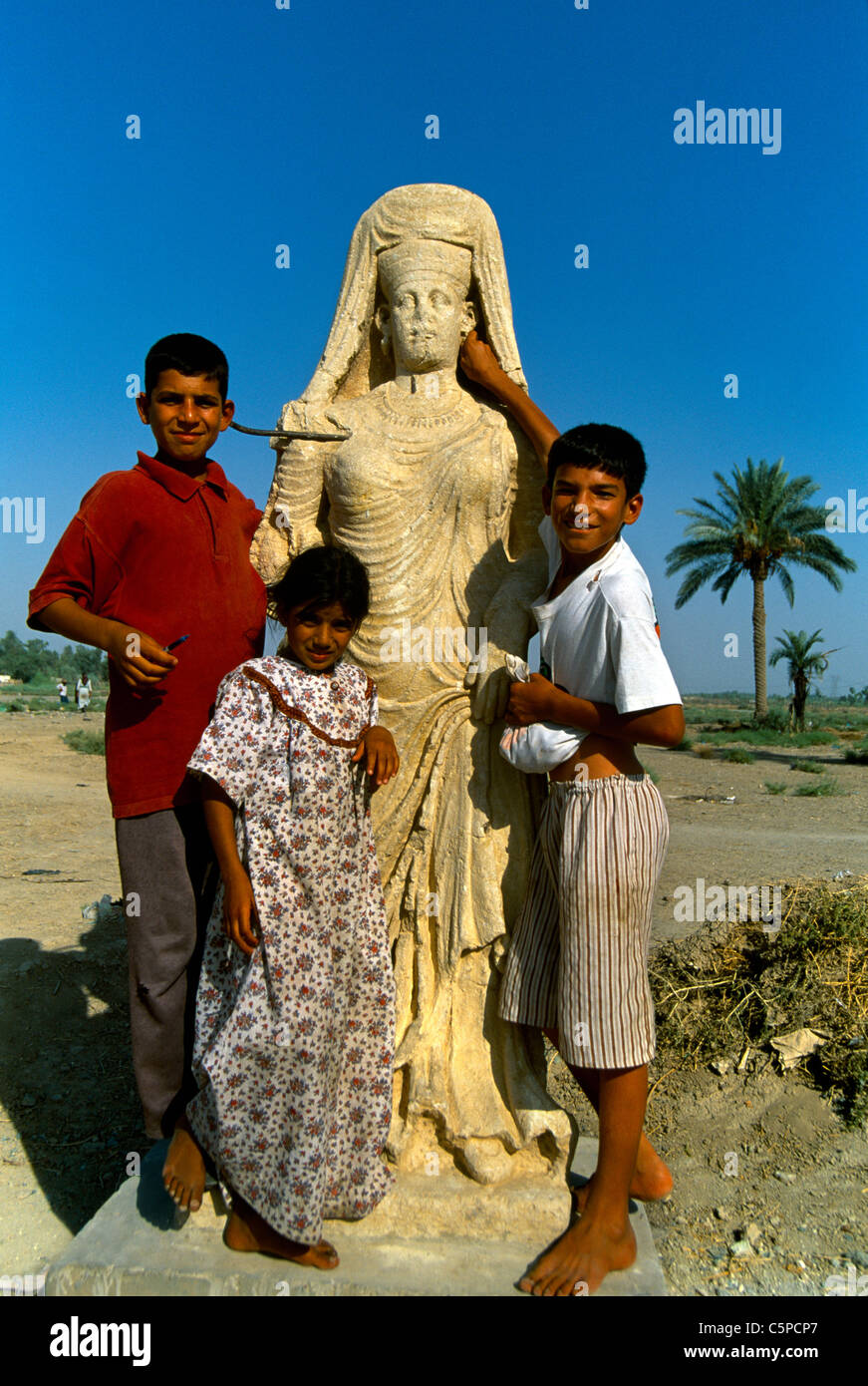 Iraq Ctesphone Children With Statue Of Queen From Hatra Al Mada'in Stock Photo