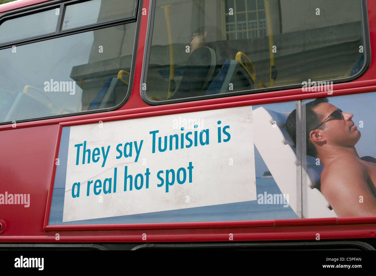 July 2011 London red bus with advertising sign They say Tunisia is a real hot spot Stock Photo