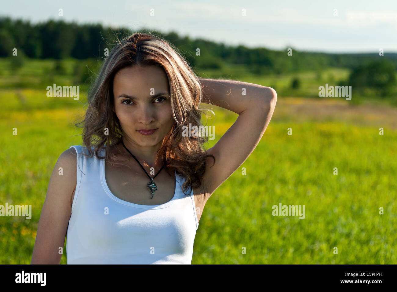 portrait of a beautiful young girl on a background of green grass Stock ...