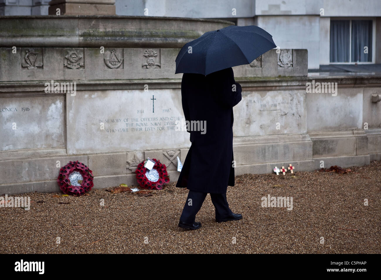 A man walks past poppy wreaths in horseguards parade after the Remembrance Parade on Whitehall. Stock Photo