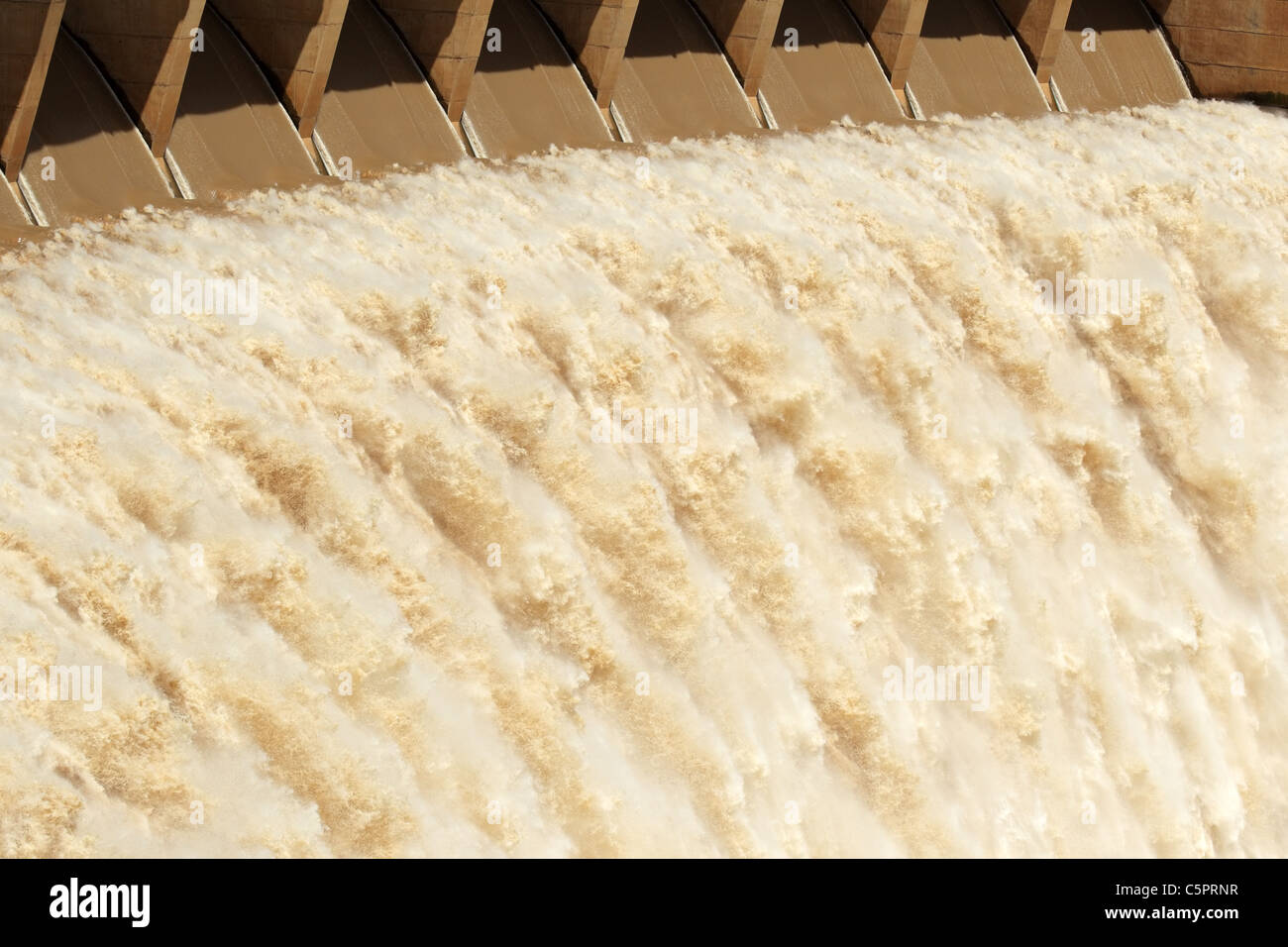 Strong flowing water released from the open sluice gates of a large dam Stock Photo